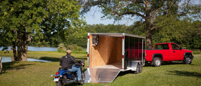 Motorcycle being driven into enclosed motorcycle trailer