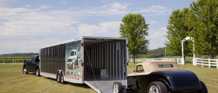 Classic car being loaded onto a large enclosed car trailer