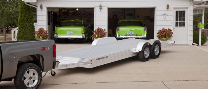 Featherlite aluminum open auto trailer in front of garage