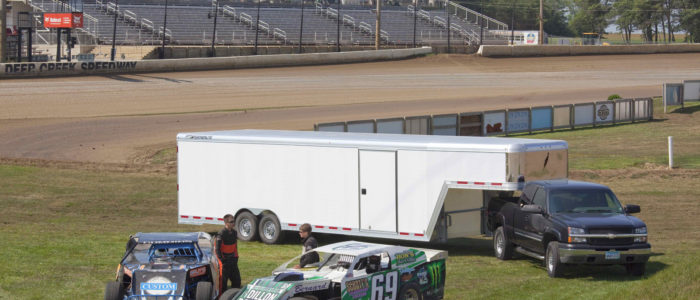 Pickup truck hauling a car trailer on racing infield