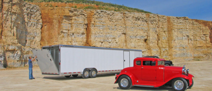 Large enclosed car trailer with red classic car