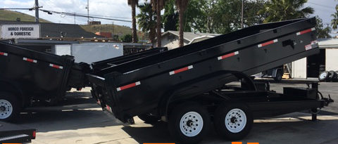 Side view of dump trailer in raised position with dump trailers text