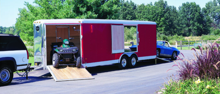 Enclosed car trailer hauling ATV and classic car
