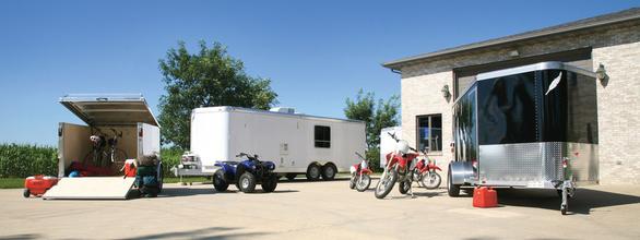 Three enclosed cargo and car trailers with motorcycles and ATVs
