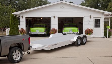 Featherlite open utility trailer in front of garage