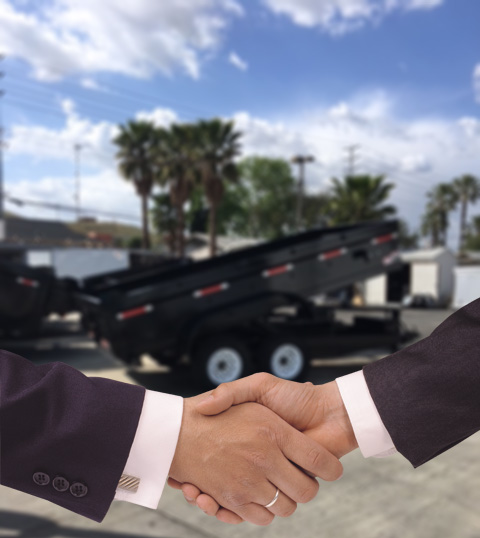 Handshake in front of dump trailers