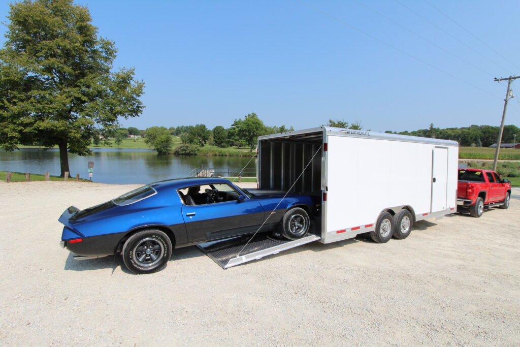 Featherlite Aluminum 4926 white race trailer with ramp door open loading blue race car
